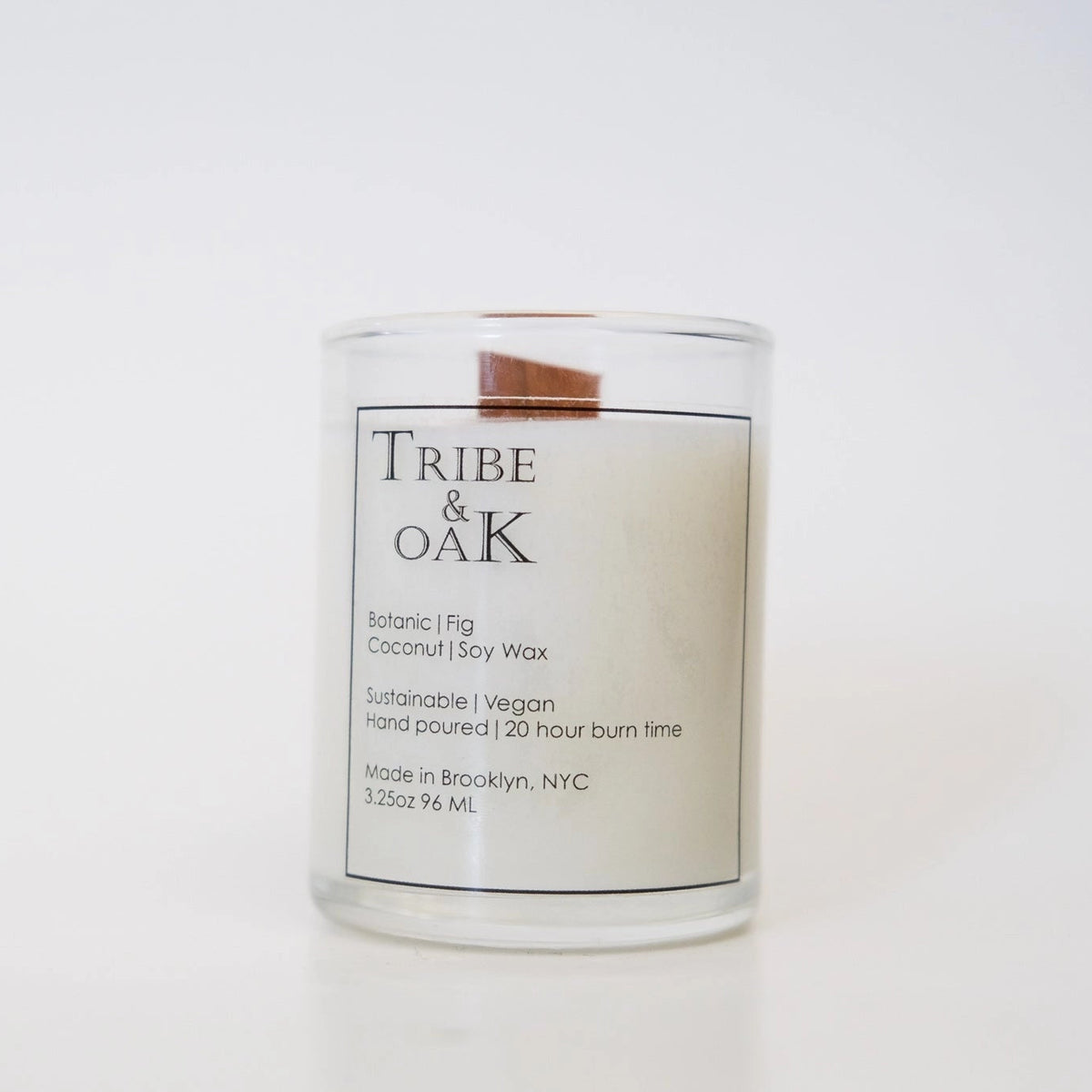 Candle with 'Tribe & Oak' label on a white background
