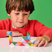 Child playing with colorful geometric shapes on a green background