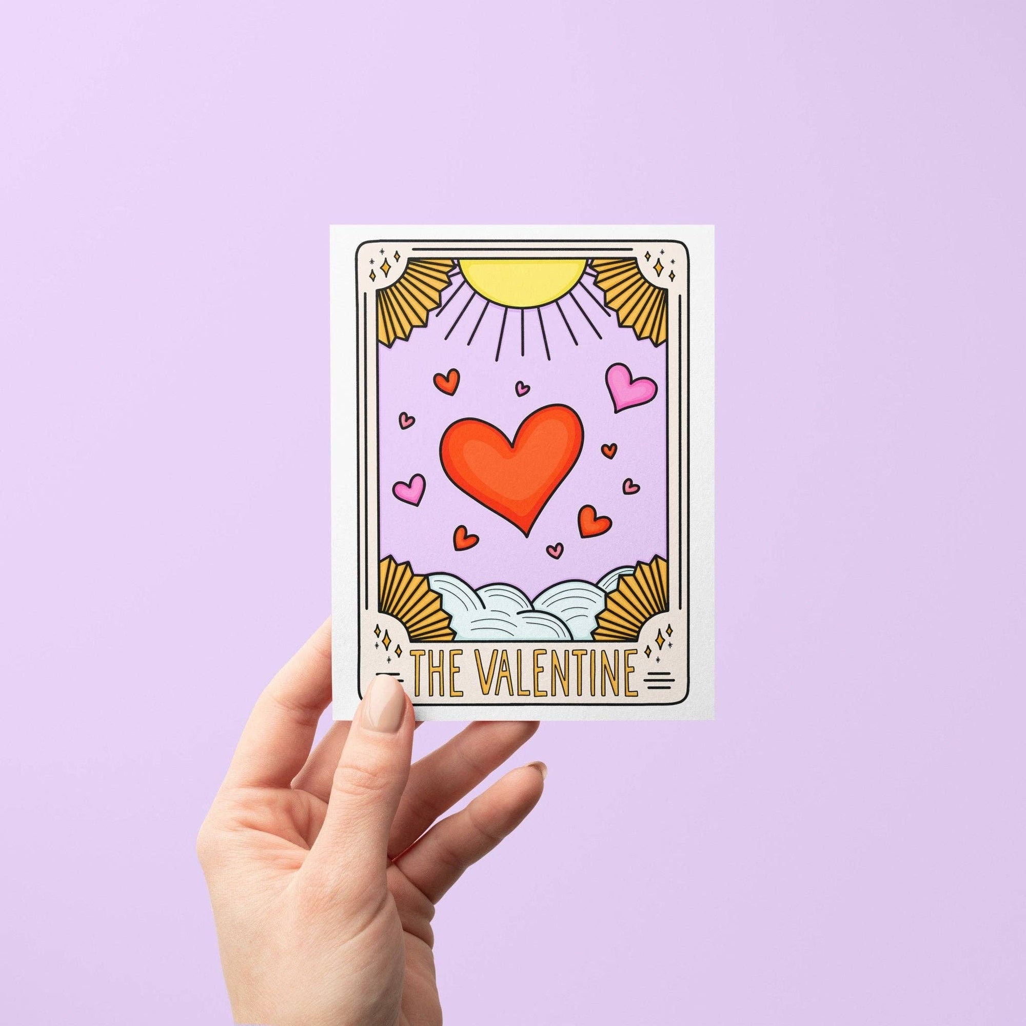Card with a heart design and 'The Valentine' text held against a purple background