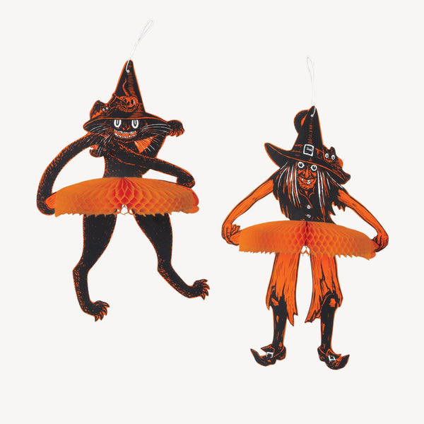 Two Halloween hanging ornaments shaped like witch cats, one standing and one crouching, both in black with orange tutus and white hanging loops, shown on a plain white background.