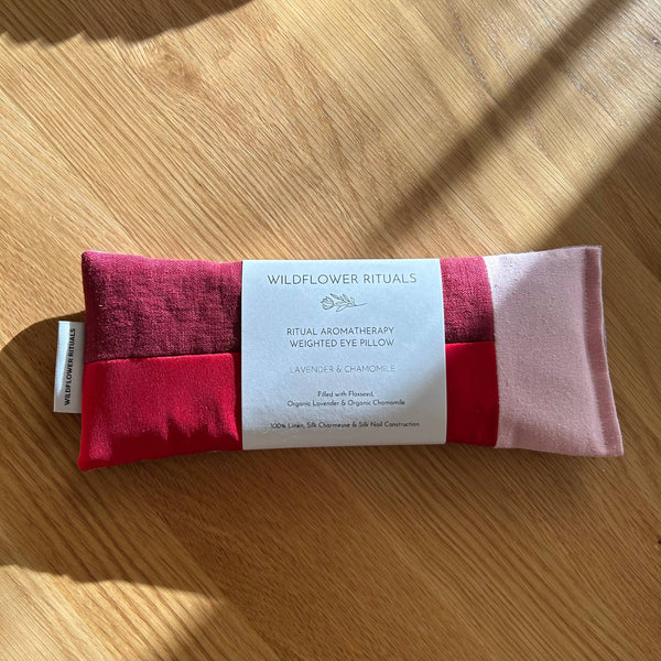 Weighted eye pillow with a label on a wooden surface