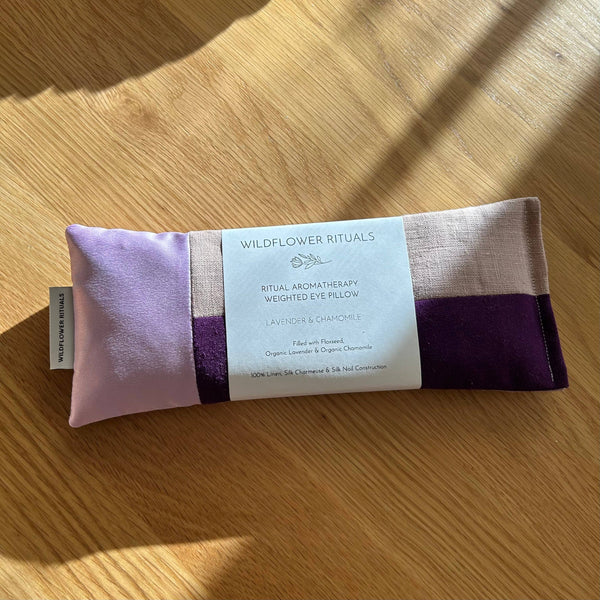 Weighted eye pillow with a label on a wooden surface