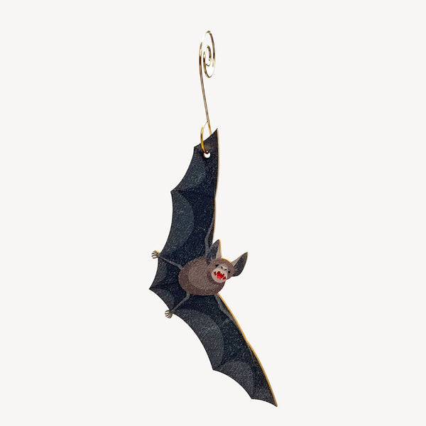Bat-shaped ornament hanging from a gold hook on a white background.