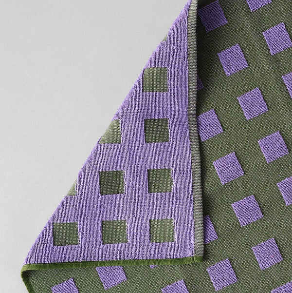 Green and purple checkered fabric on a gray background