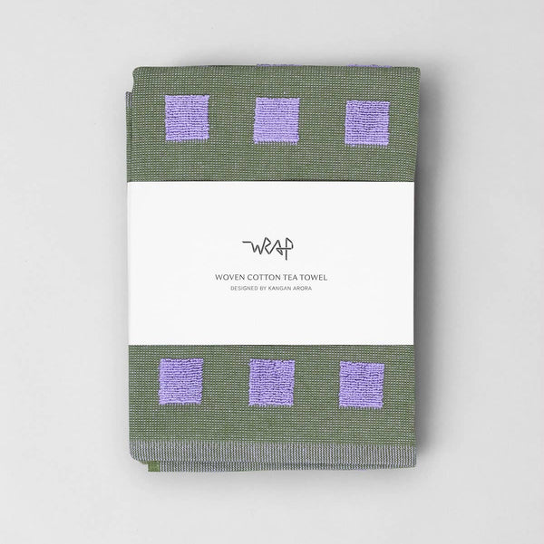Green woven cotton tea towel with purple squares on a white background