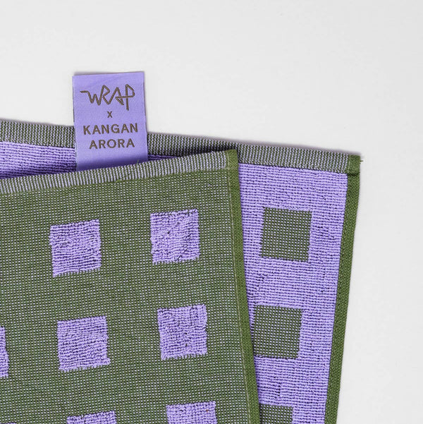 Green and purple patterned fabric with a visible brand tag on a white background