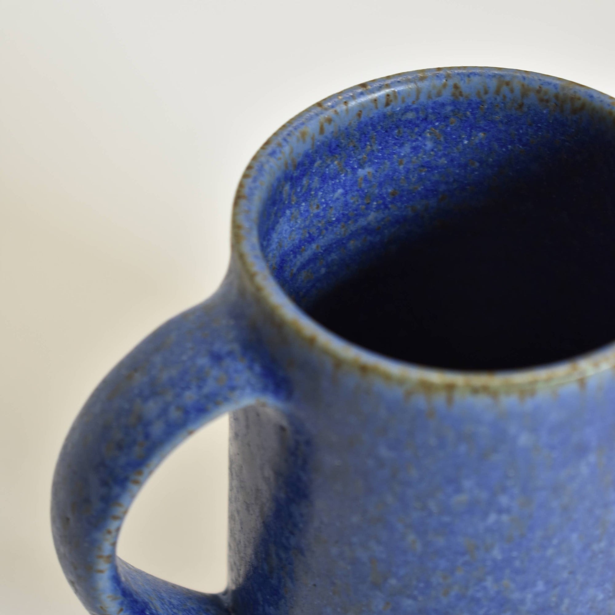 Detail of a blue ceramic mug on a white background