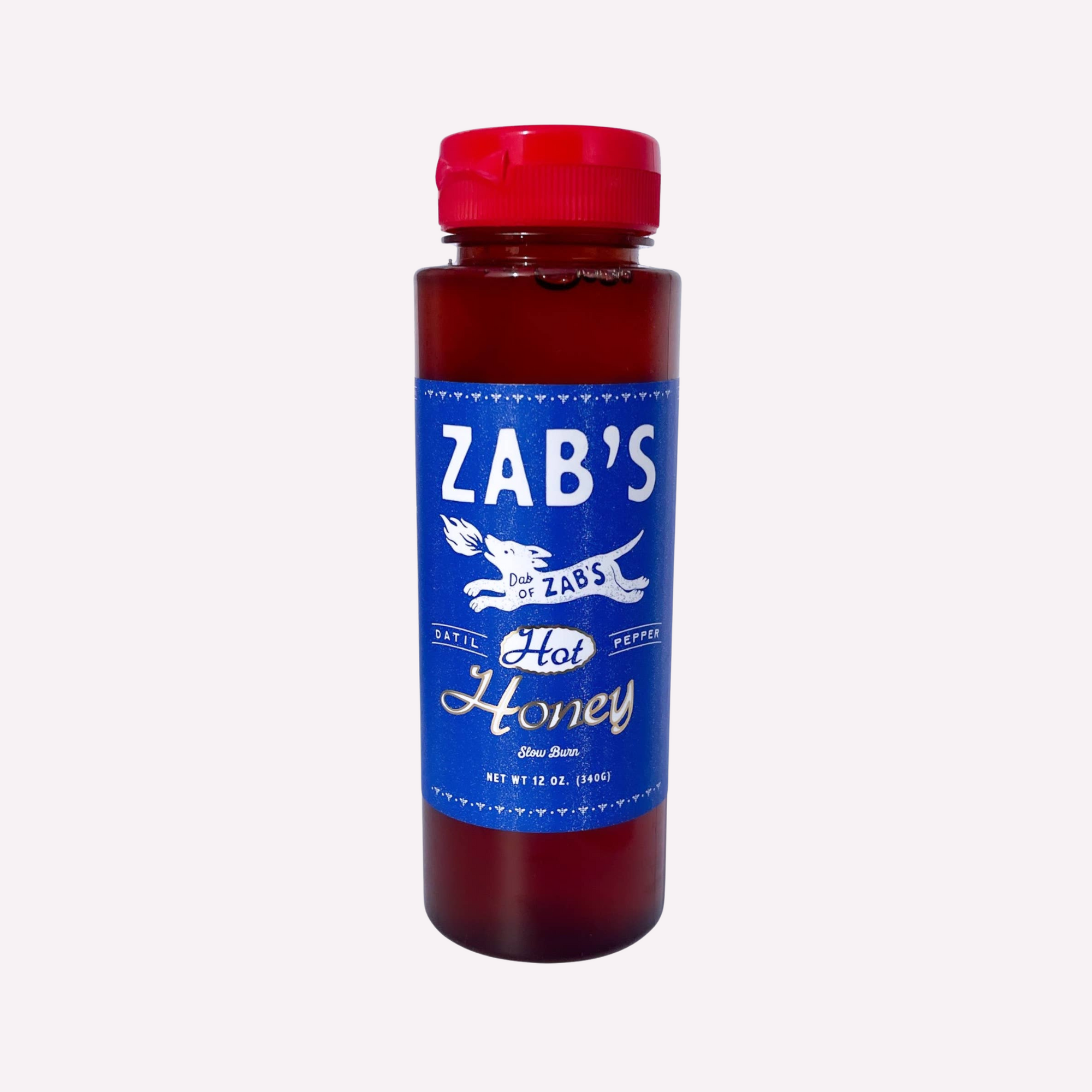 A bottle of Zab's Hot Honey with a blue label and red cap, displaying the product name andDatil pepper illustration.